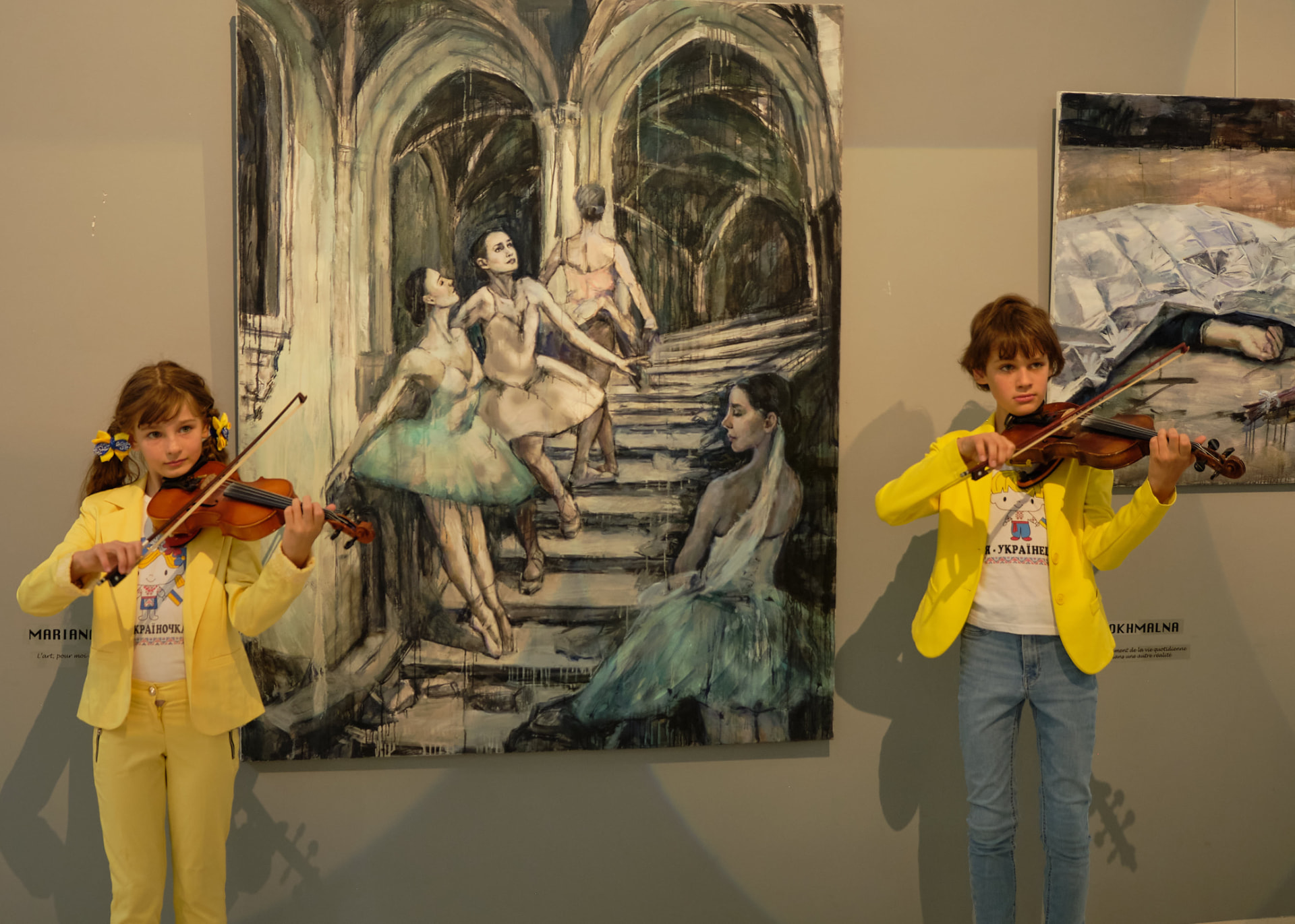 Deux jeunes violonistes devant une peinture de danseuses