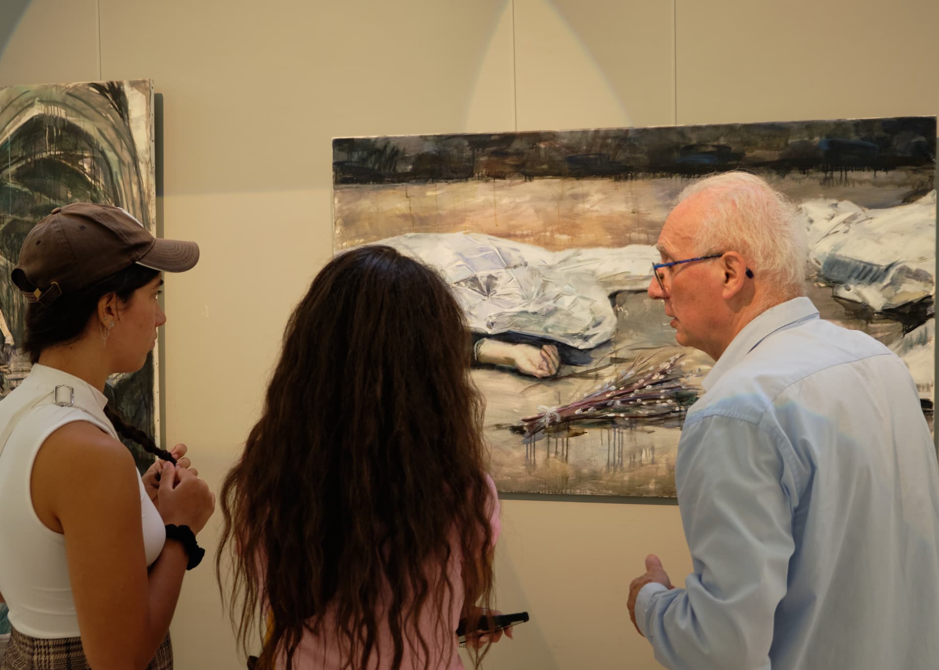 Visiteurs devant une grande peinture de l'exposition