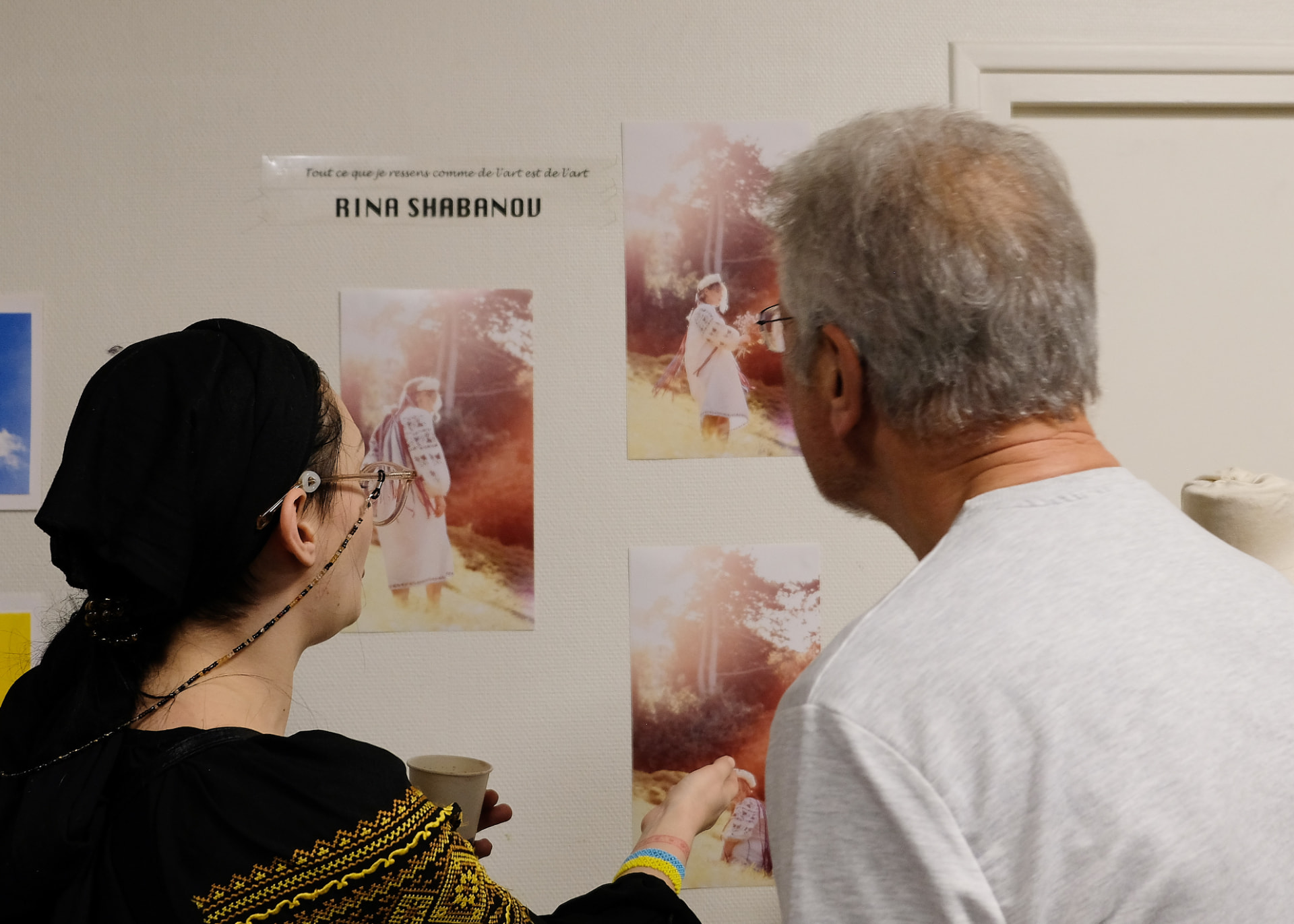 Visiteurs admirant les photographies de Rina Shabanov