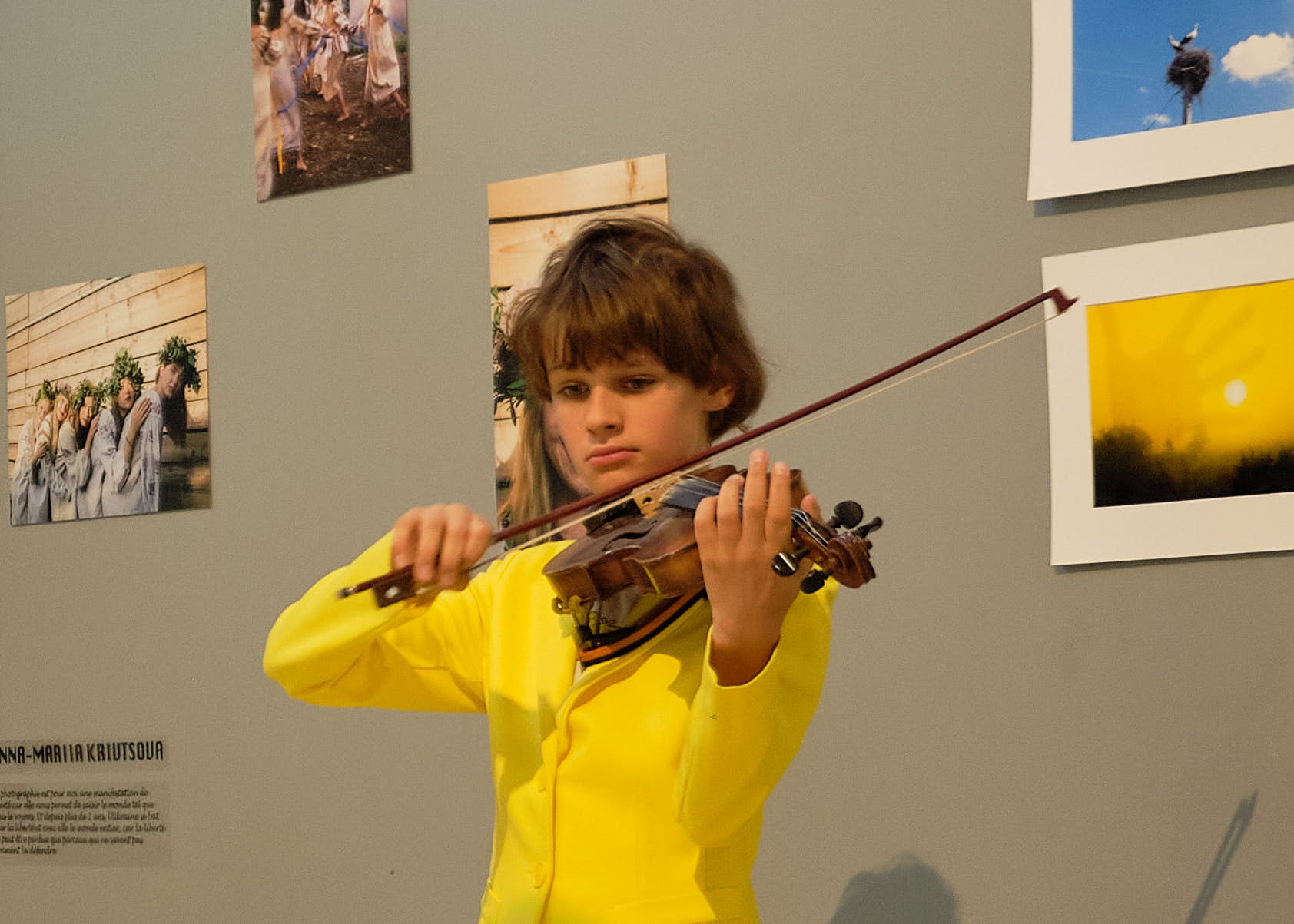 Jeune violoniste devant les photographies d'Anna-Mariia Kryvtsova